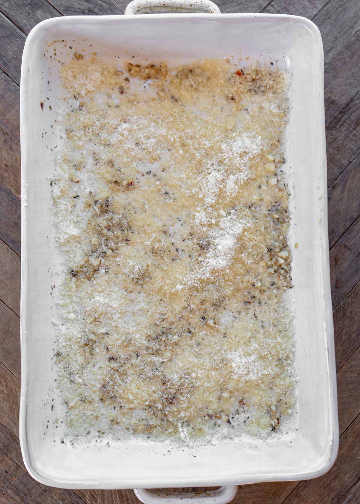 a casserole dish with garlic butter and parmesan