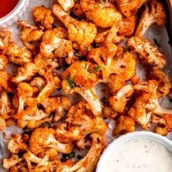 close overhead image of buffalo cauliflower and dipping sauce on sheet pan