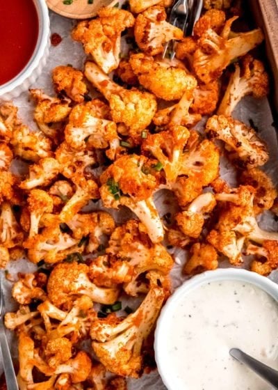 close overhead image of buffalo cauliflower and dipping sauce on sheet pan