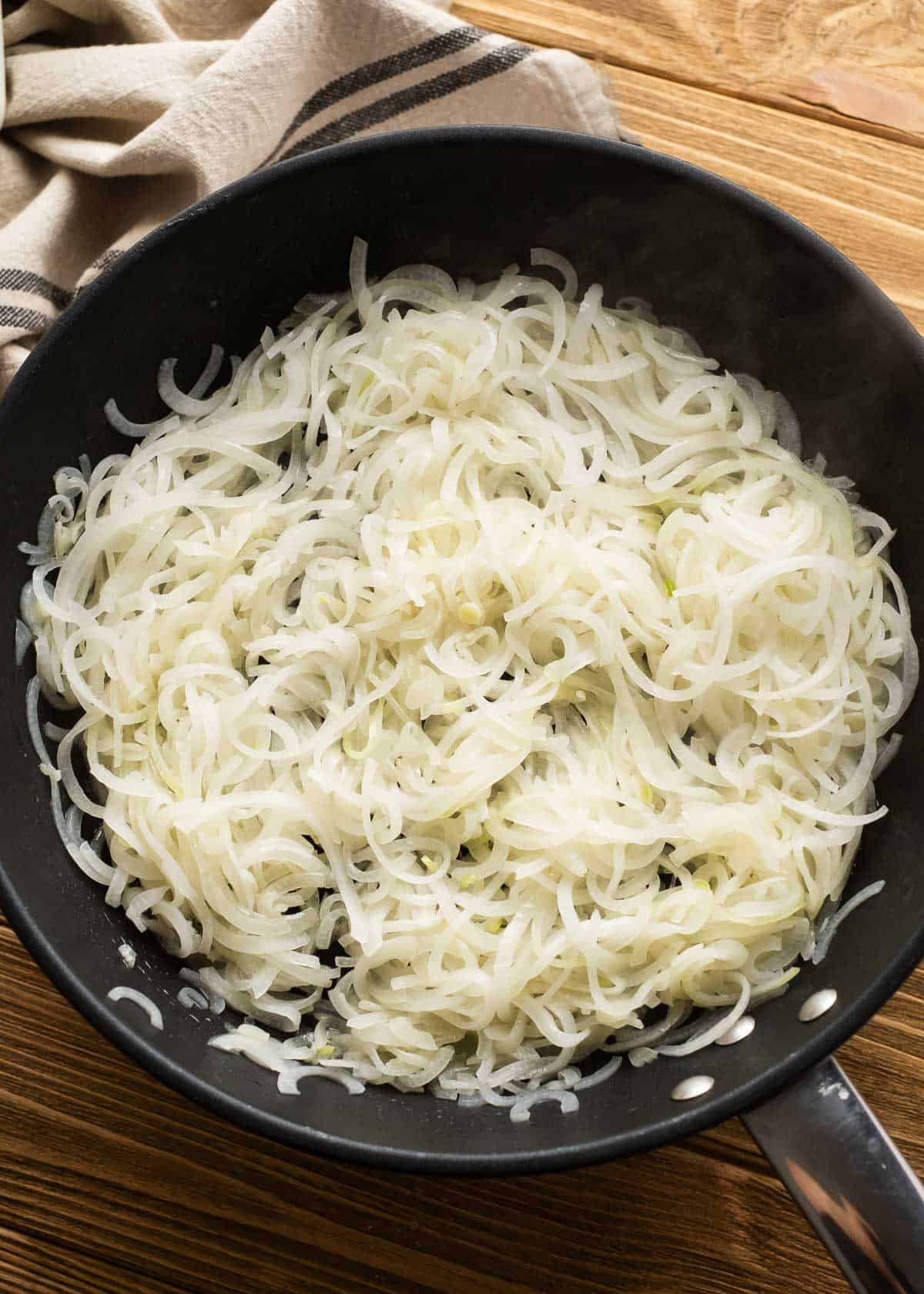 overhead shot of white onions in a cast iron skillet 