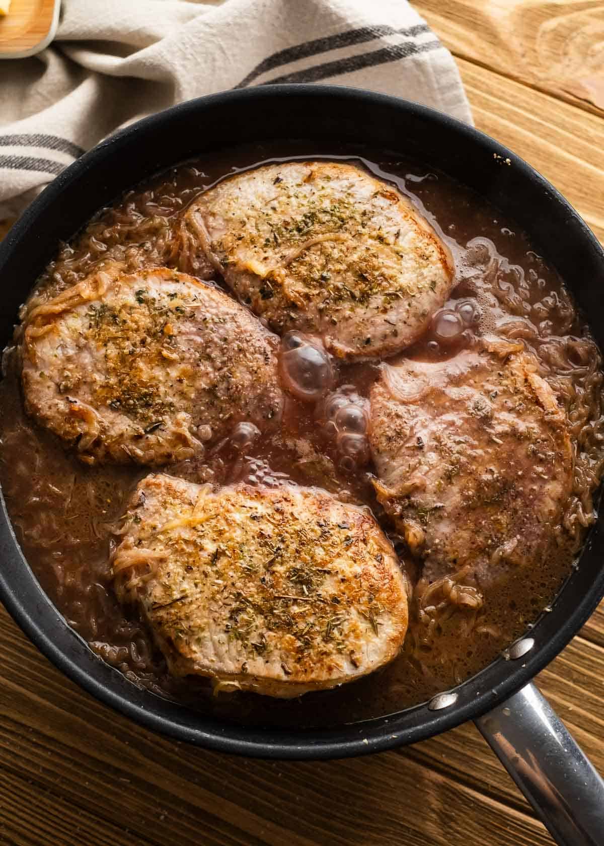 pork chops in french onion sauce in cast iron skillet