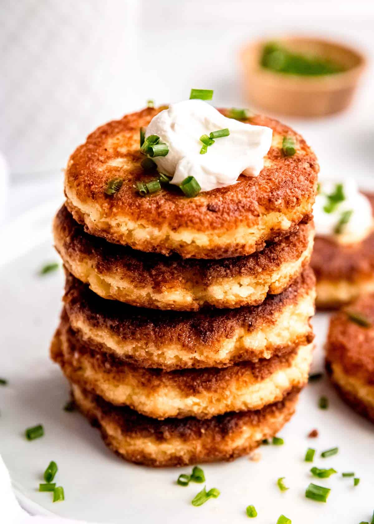 an overhead shot of cauliflower fritters with sour cream and chives