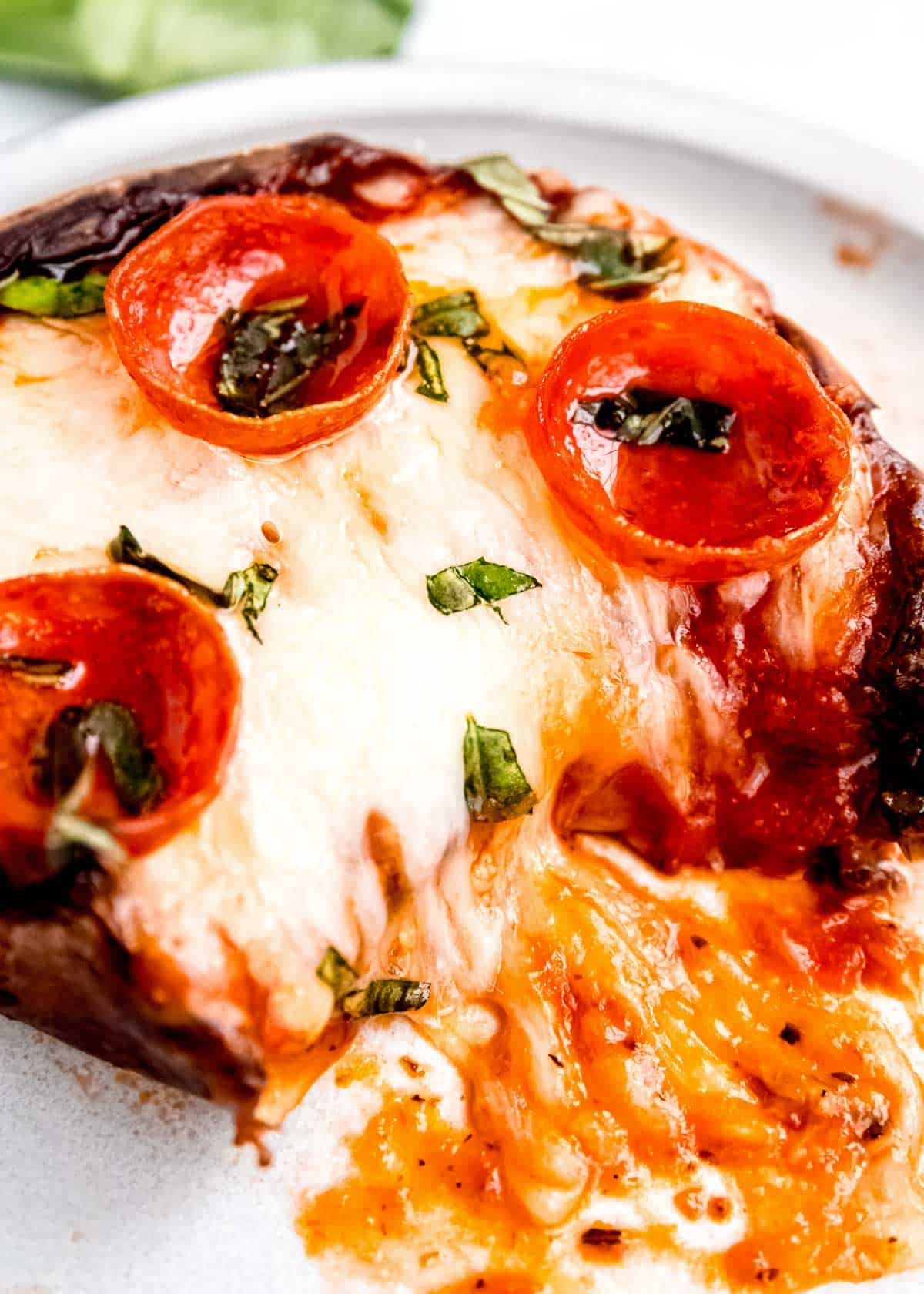 close up of pizza stuffed mushrooms on a white plate