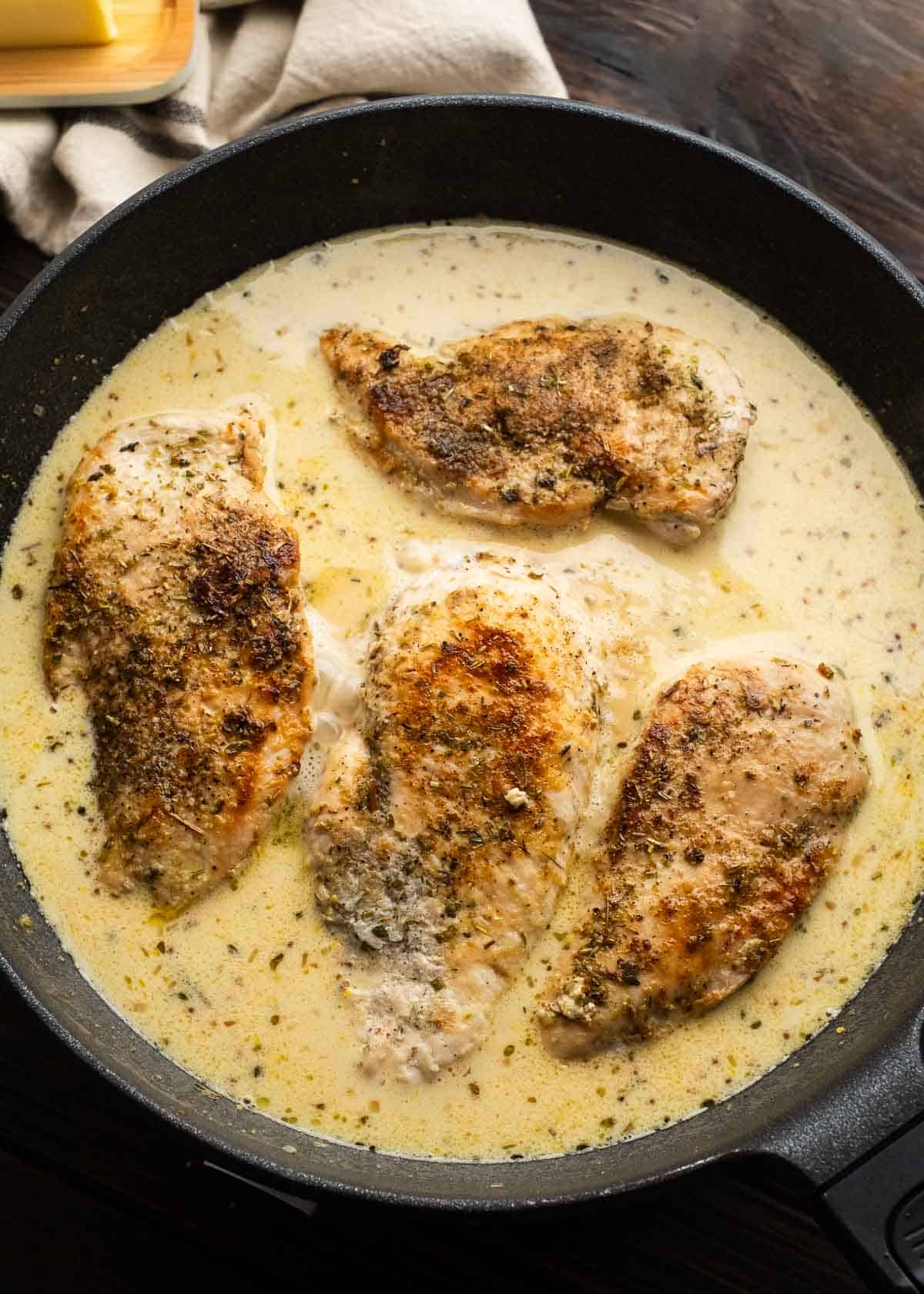 chicken breasts in mustard cream sauce in cast iron skillet
