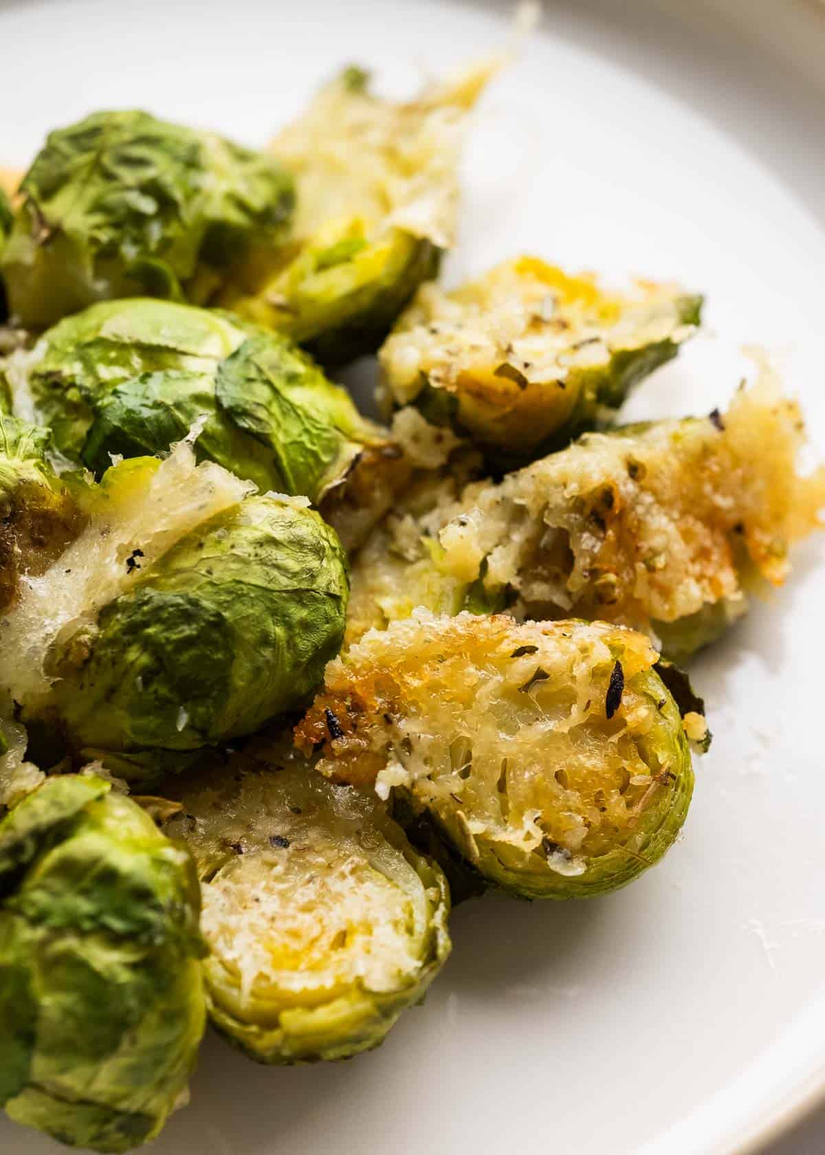 close up image of parmesan brussels sprouts on a white plate