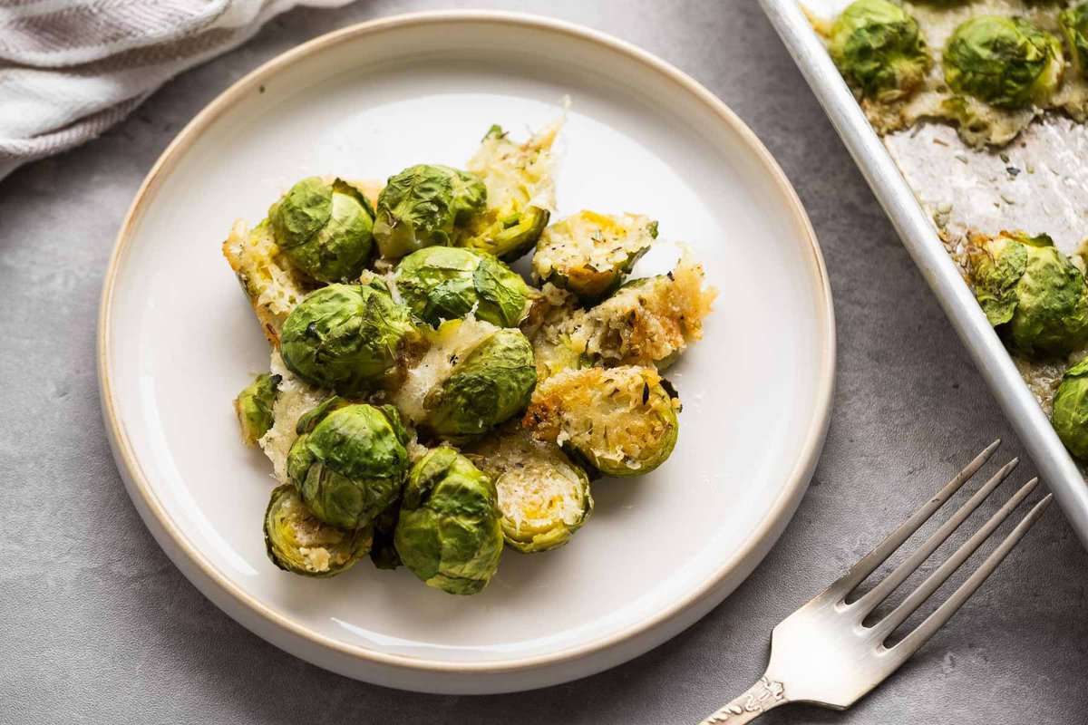 overhead image of parmesan crusted brussels sprouts on a white plate