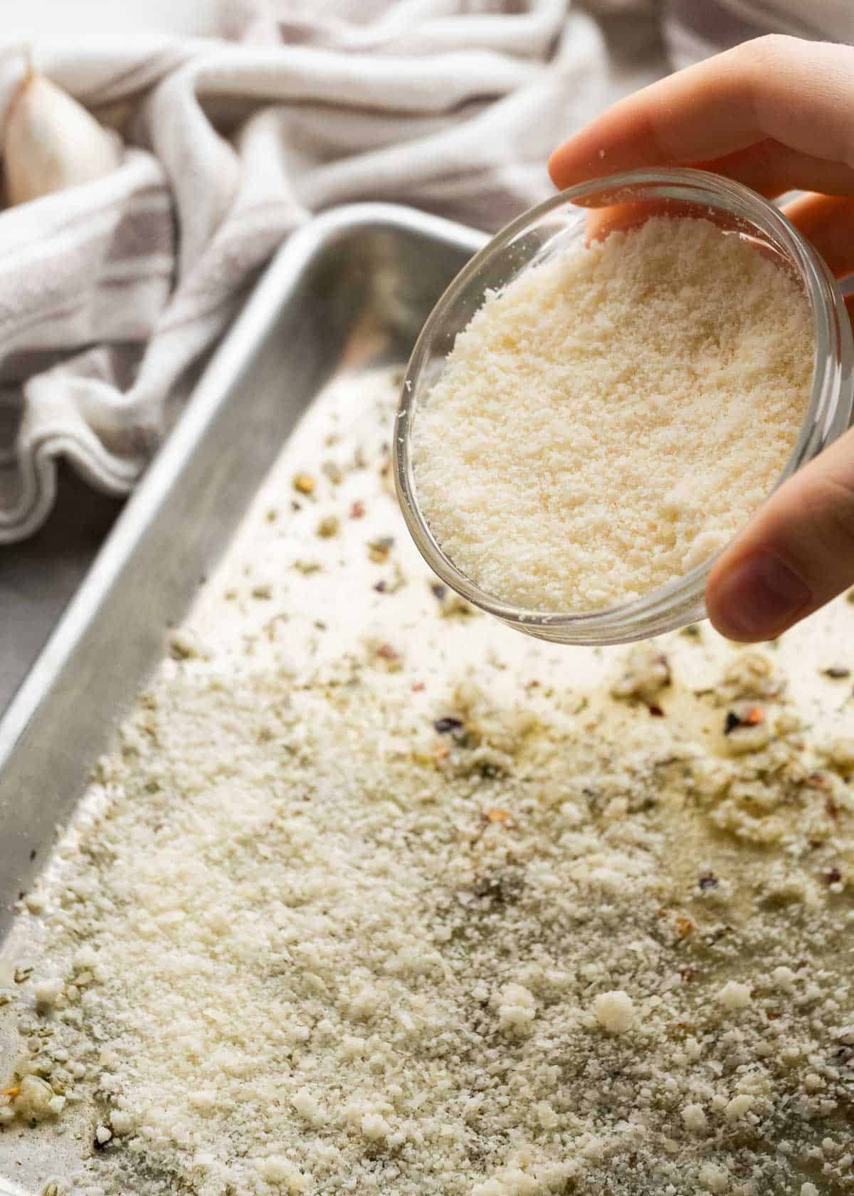 parmesan mixture being spread on sheet pan