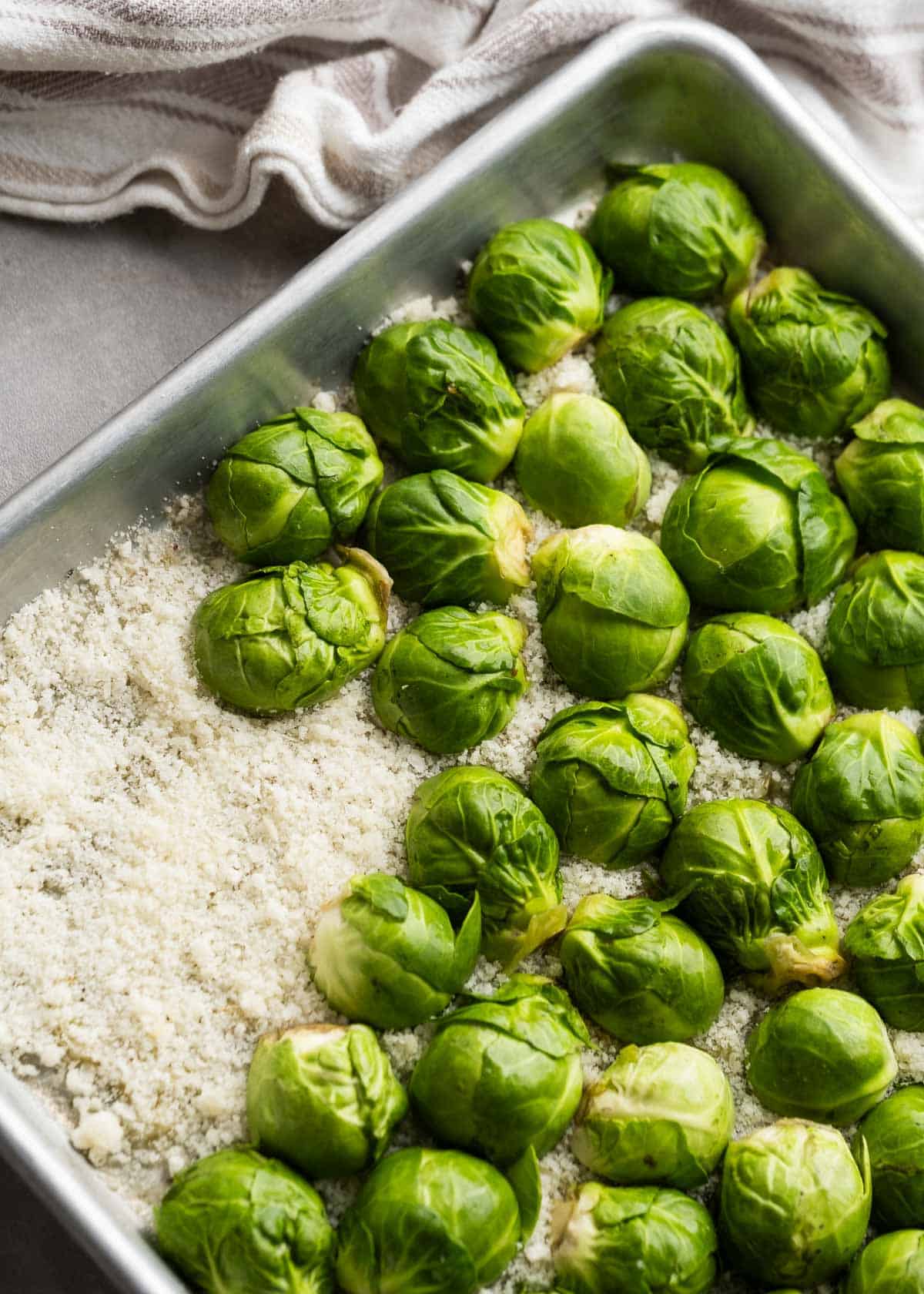 brussels sprouts being added to sheet pan