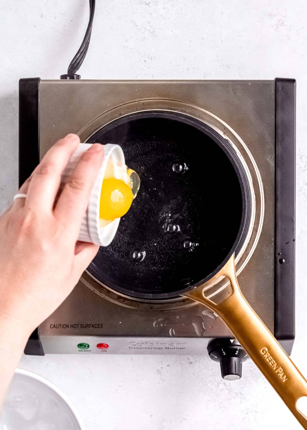 overhead image of egg being added to simmering water