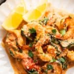 close up image of creamy tuscan shrimp in a white plate