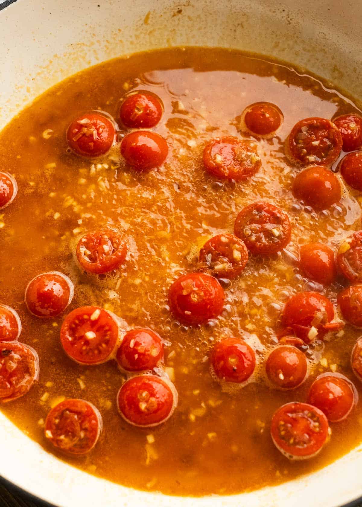 tomatoes and shallots being sauteed in pan