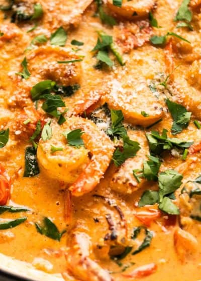 close up image of creamy tuscan shrimp in white pan
