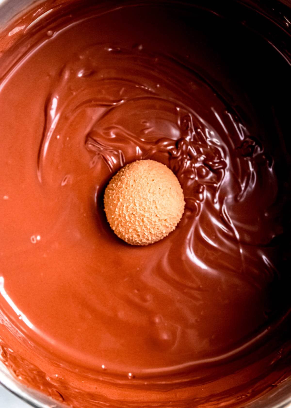 espresso truffle being dipped in chocolate coating