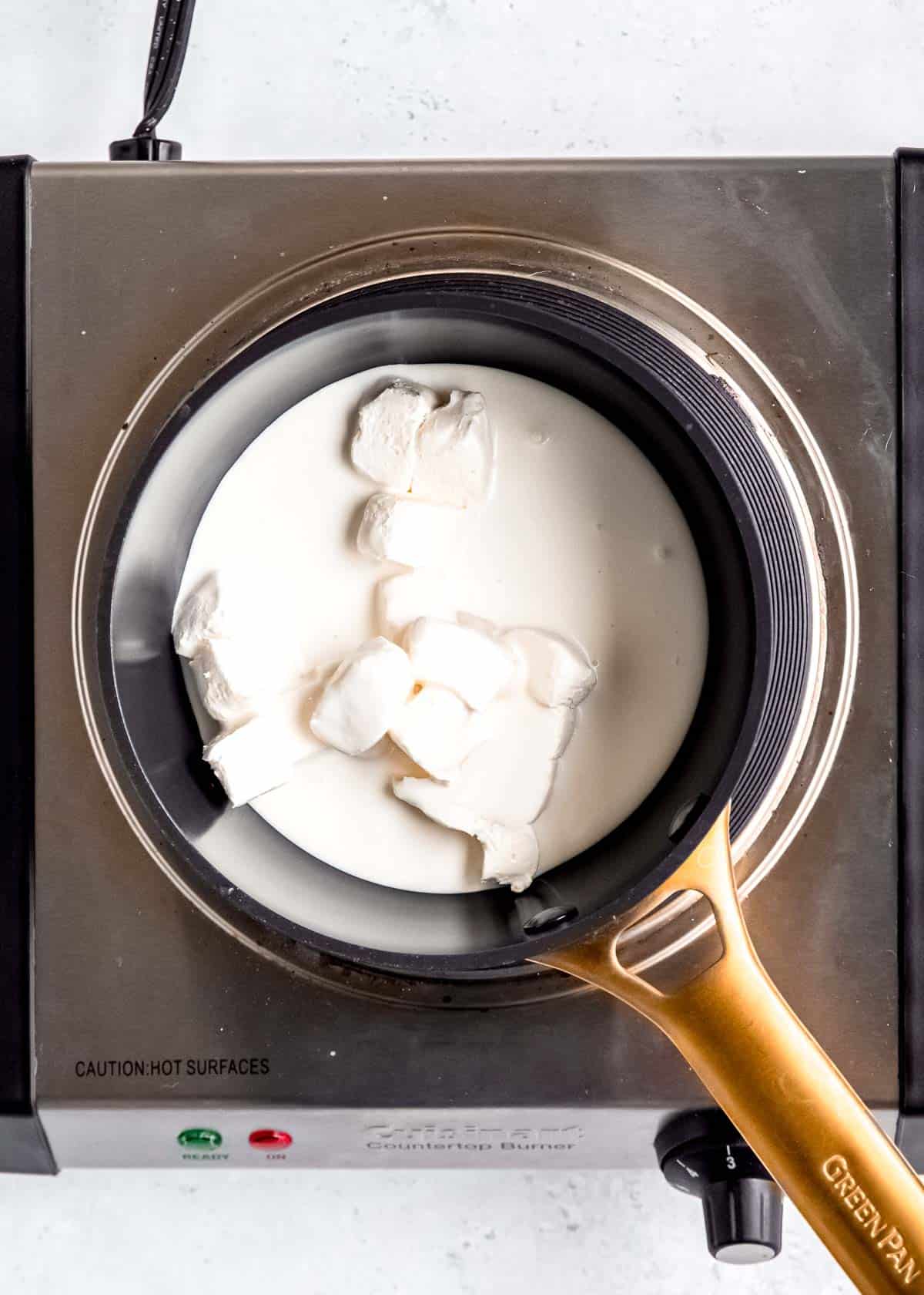 overhead image of heavy cream and cheese cheese in a silver pot