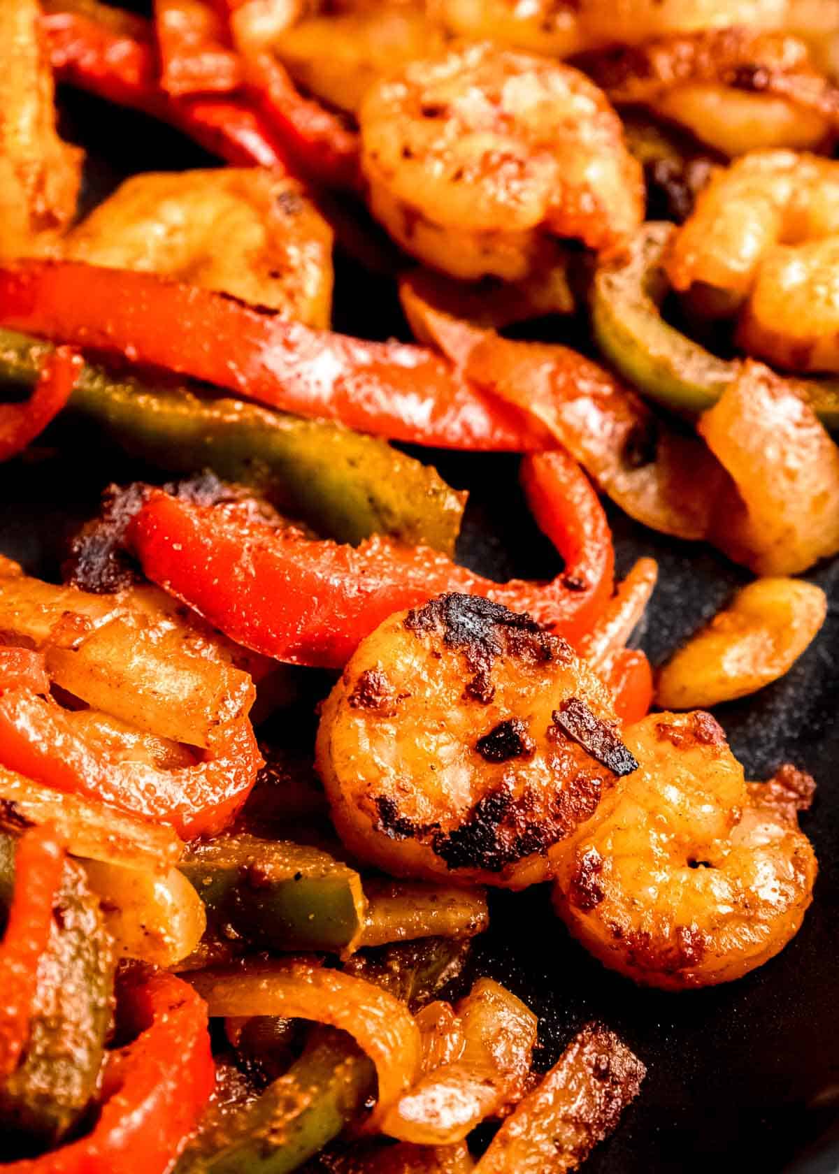 close up image of shrimp and veggies in a black skillet