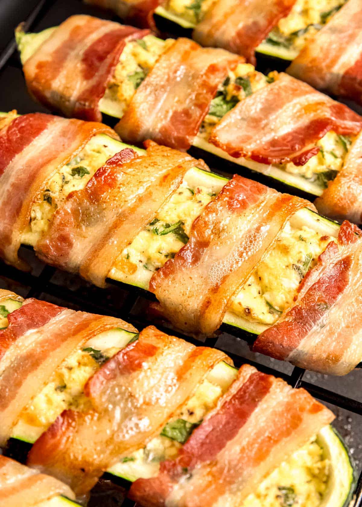 close up image of cooked bacon wrapped zucchini boats