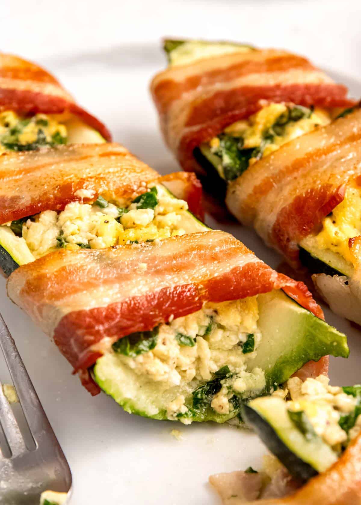 close up image of bacon wrapped zucchini with slice missing