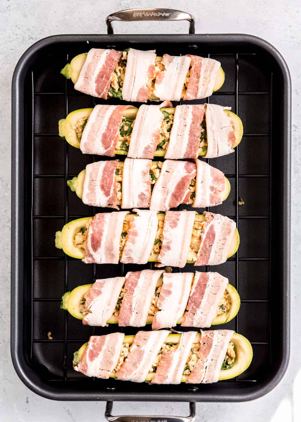 overhead image of uncooked bacon wrapped zucchini boats