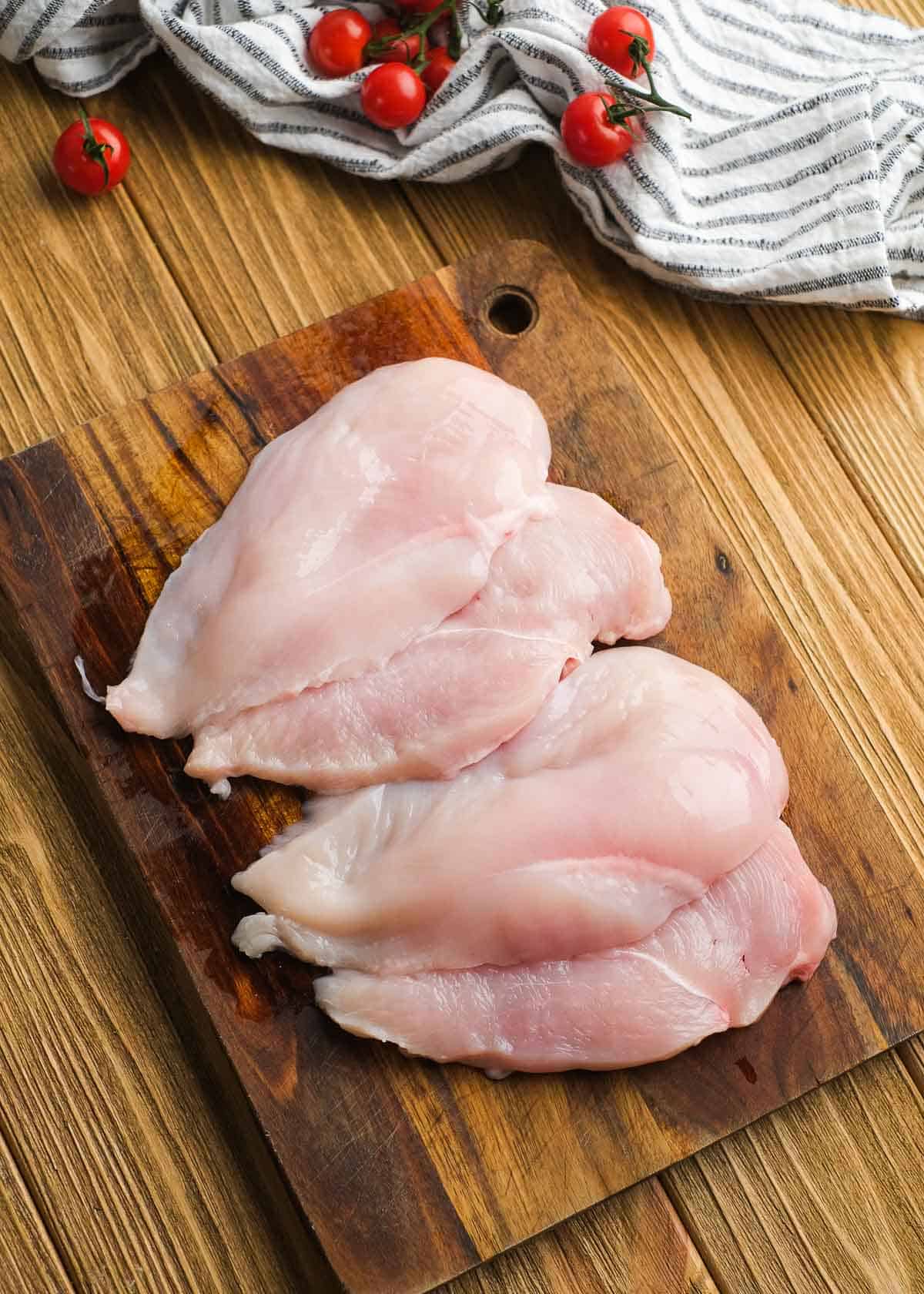 butterflied chicken on a wooden cutting board