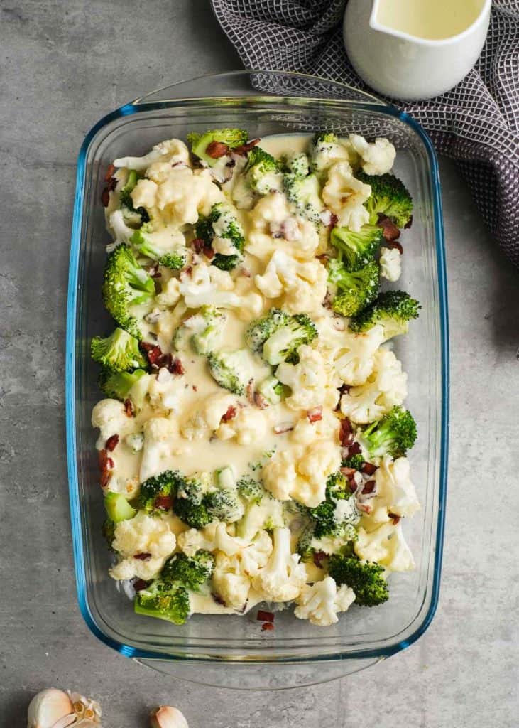 lightly roasted broccoli and cauliflower in a casserole dish with crunchy bacon and a creamy sauce