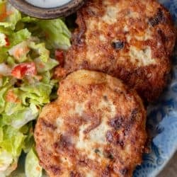 close up image of two chicken fritters on a blue plate