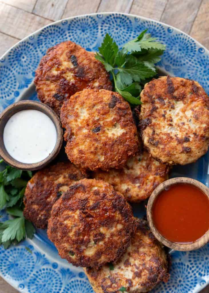 overhead image of cheesy chicken fritters on a blue plate