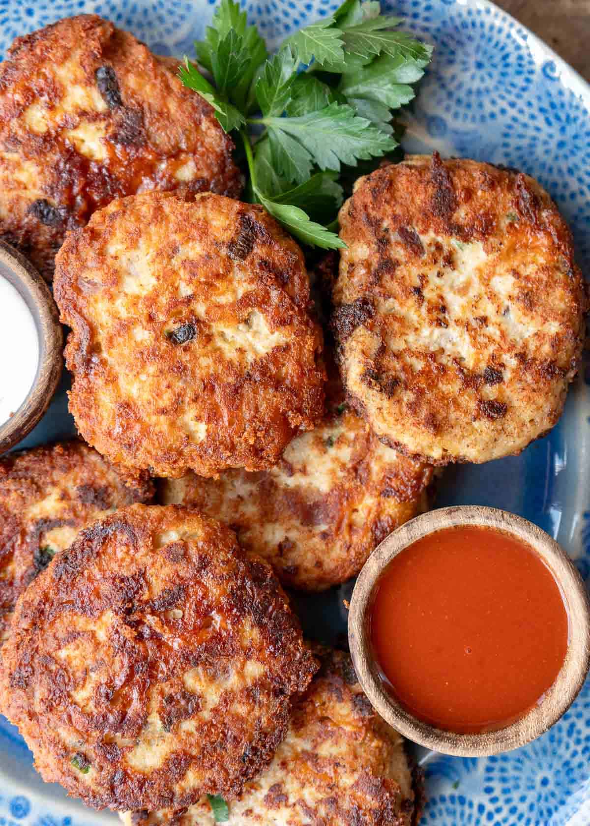 overhead image of cheesy chicken fritters on a blue plate
