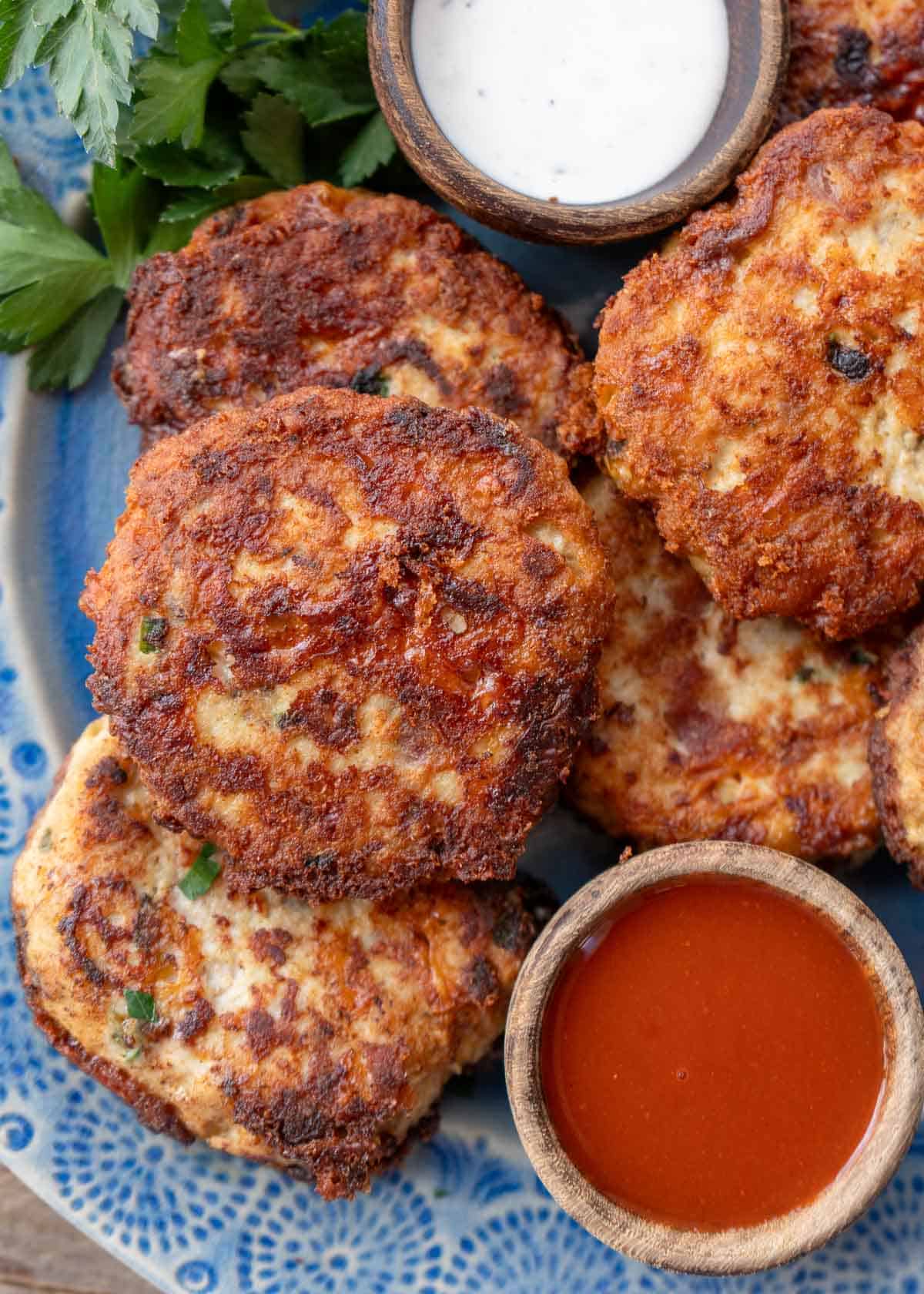 close up, overhead image of cheesy chicken fritters on a blue plate