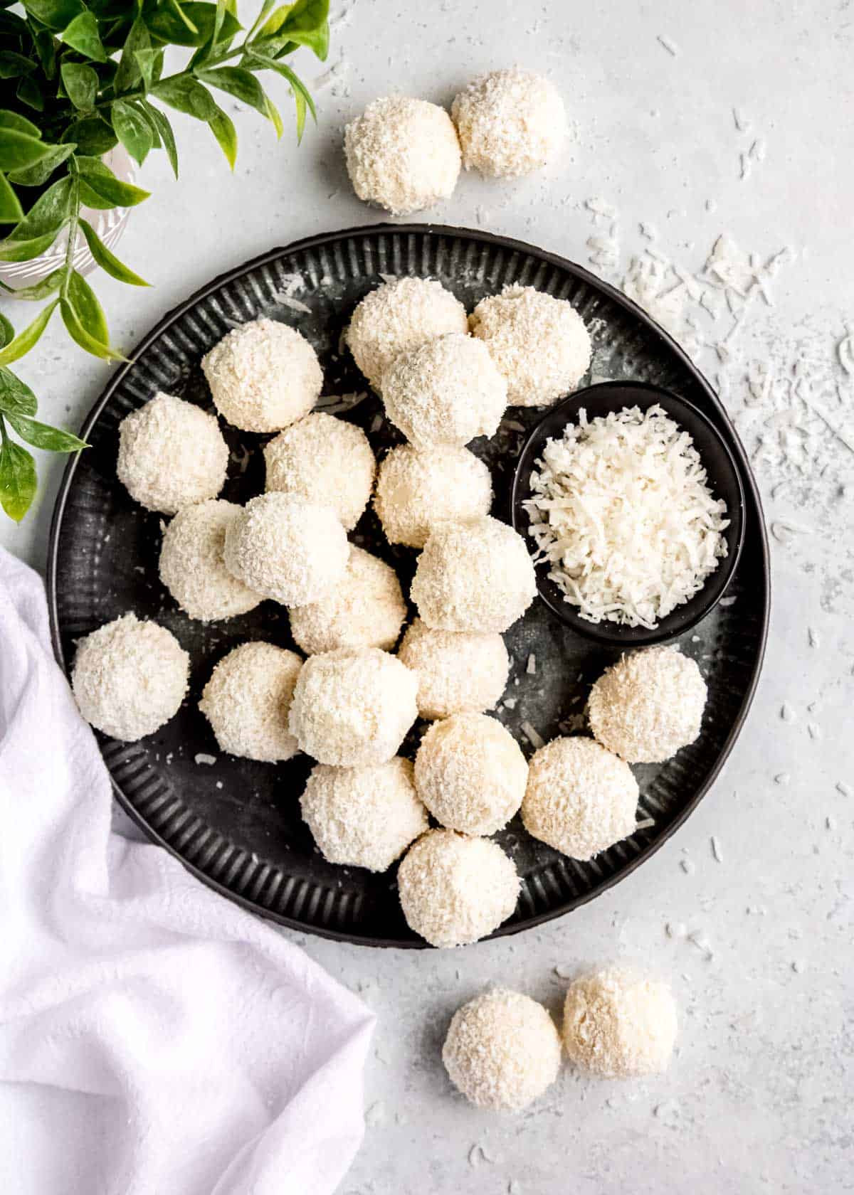 overhead image of coconut truffles on a black plate