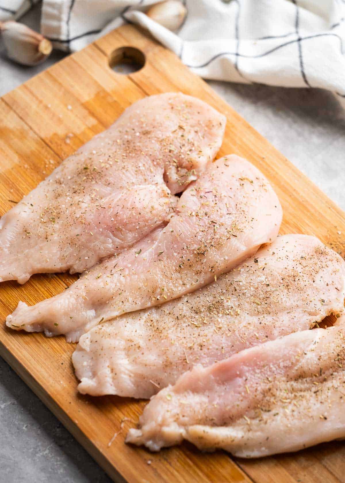 sliced chicken breasts on a wooden cutting board