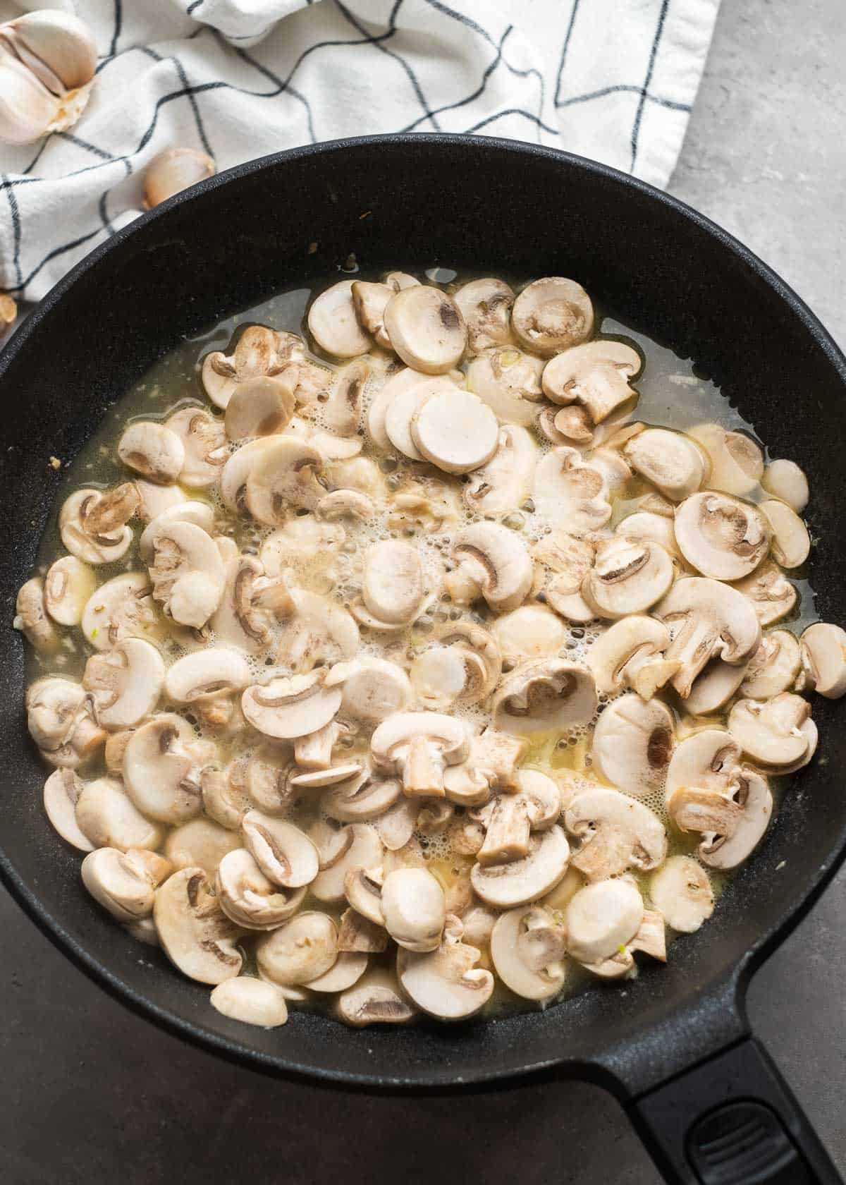 creamy mushroom chicken ingredients being added to skillet