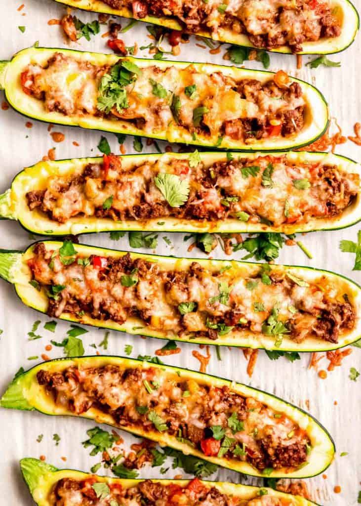 overhead shot of six beef enchilada stuffed zucchini boats topped with cheese and cilantro