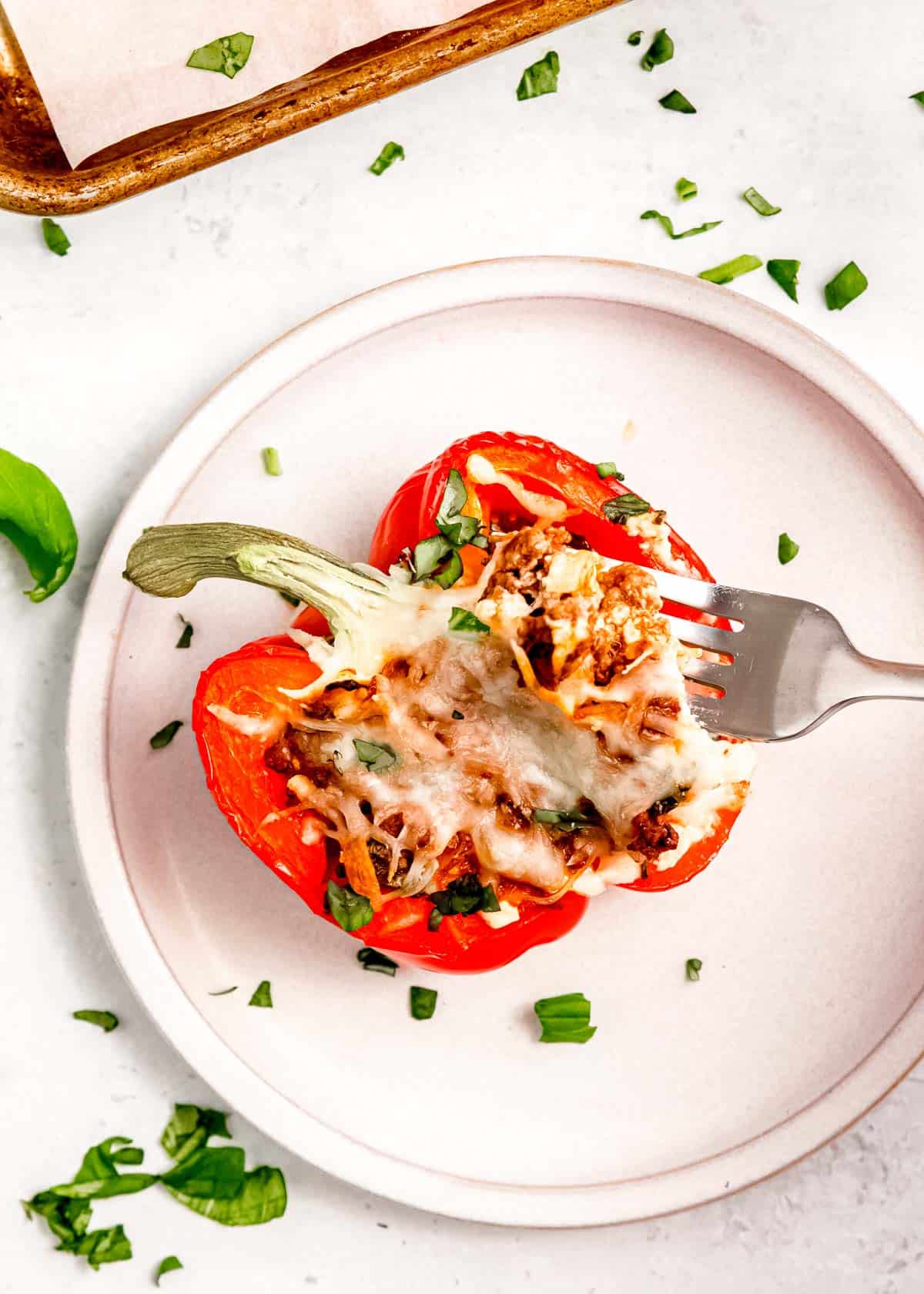 overhead image of bite being removed from stuffed pepper with fork