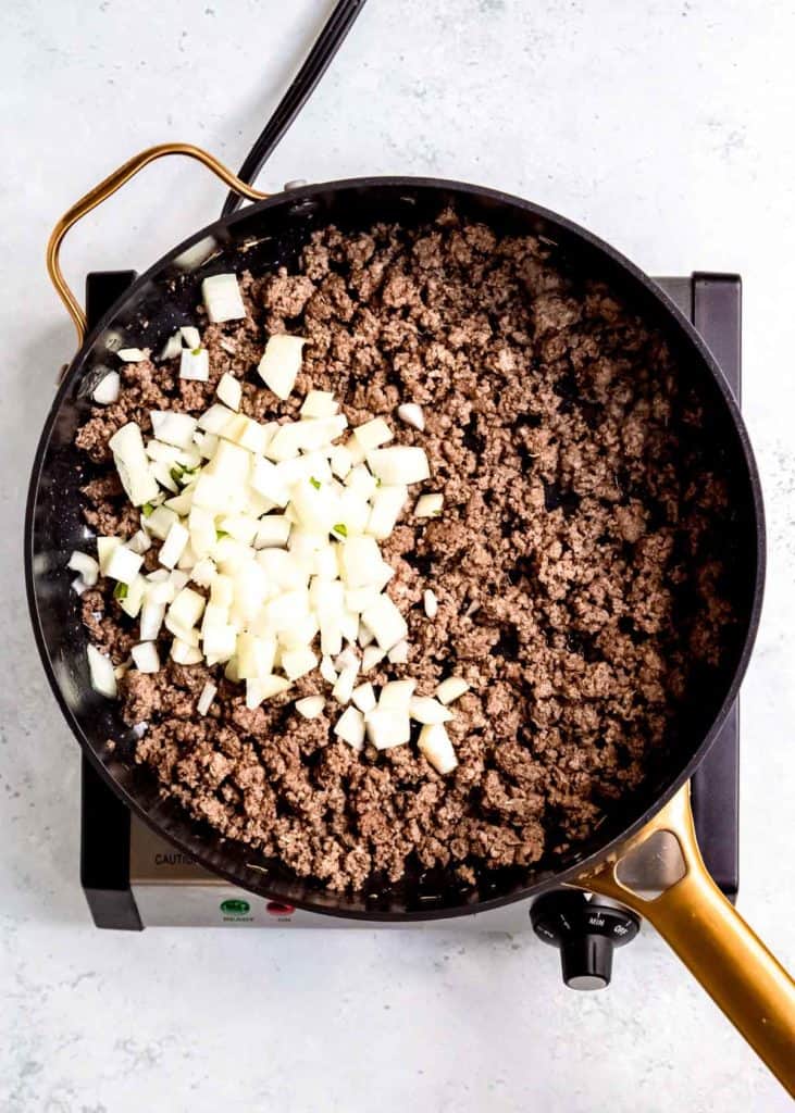 ground beef and onion in cast iron skillet