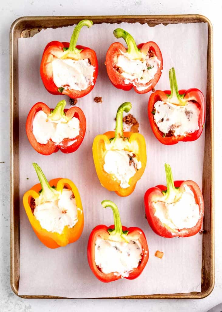 cheese being added  to stuffed peppers