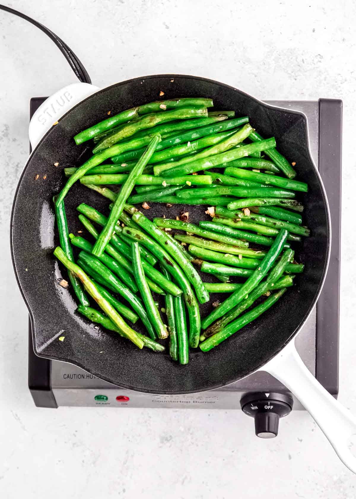 overhead image of sauteed green beans in a skillet