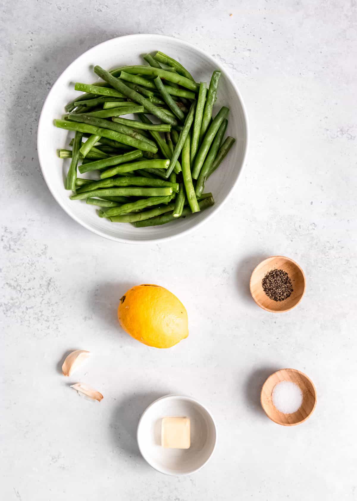 overhead image of lemon pepper green bean ingredients on a white table