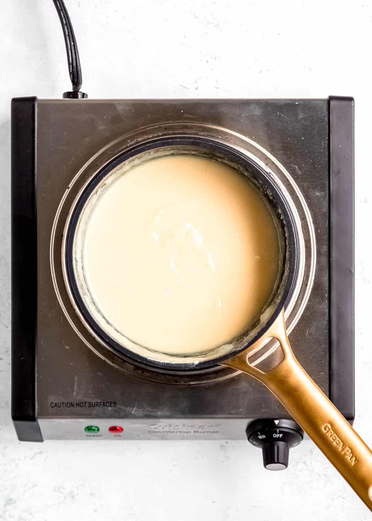 melted white chocolate and other truffle ingredients in saucepan