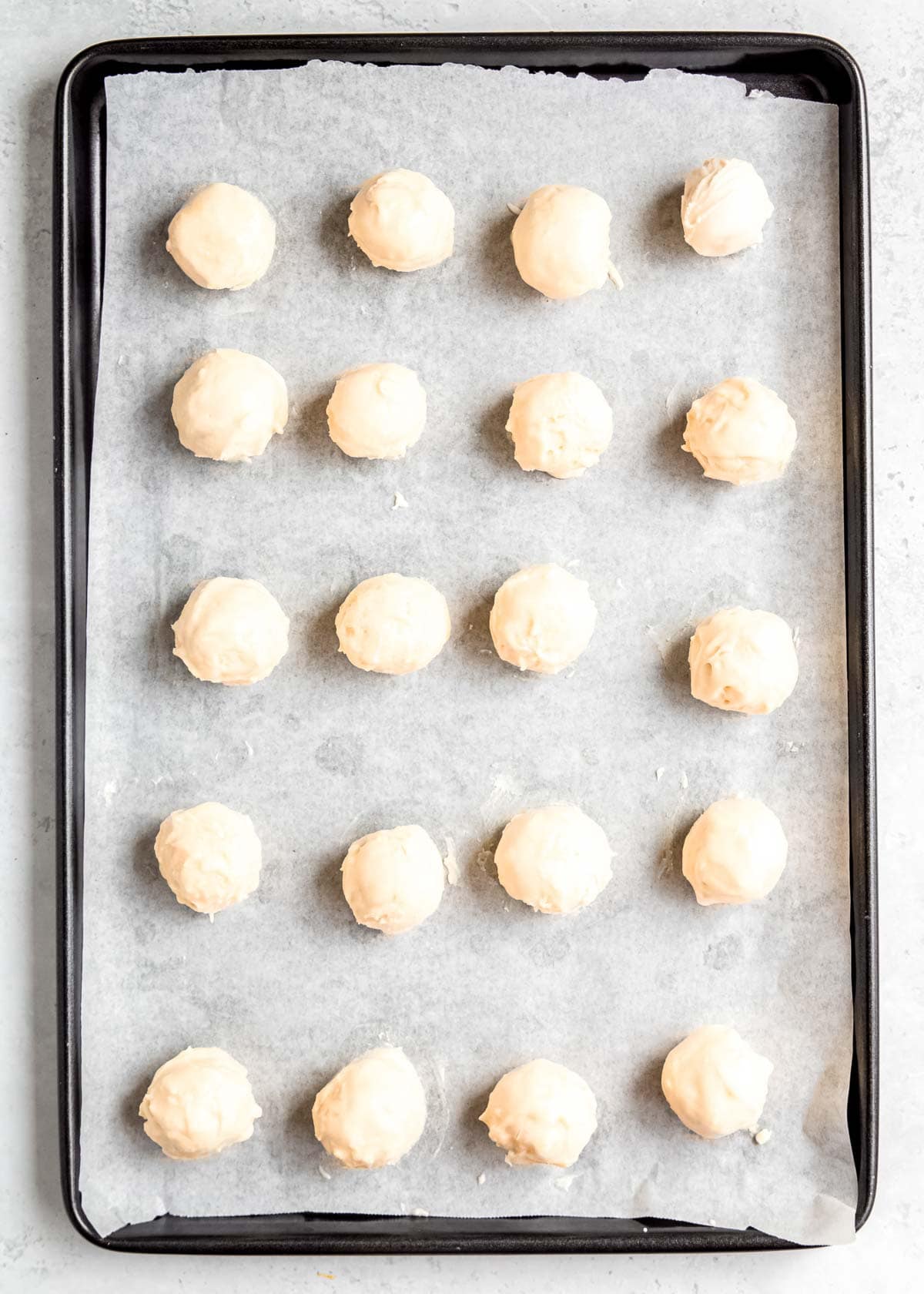 coated lemon truffles on a sheet pan