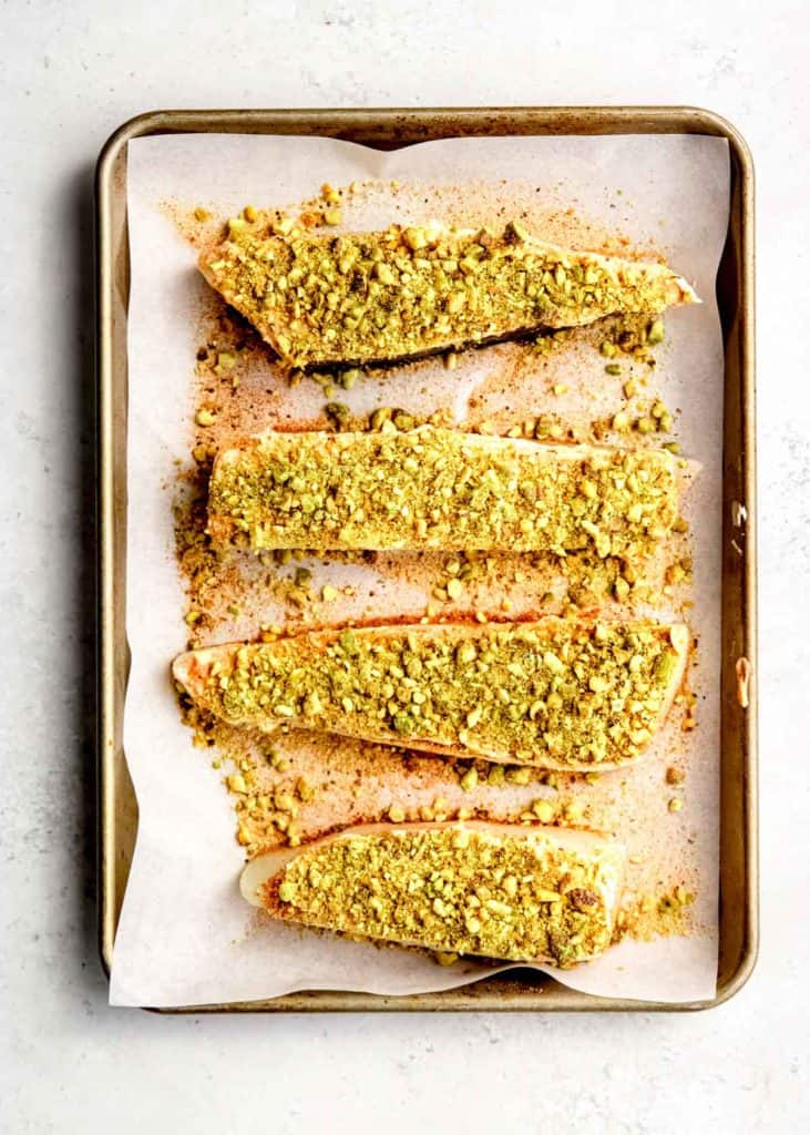 pistachios being added to halibut filets