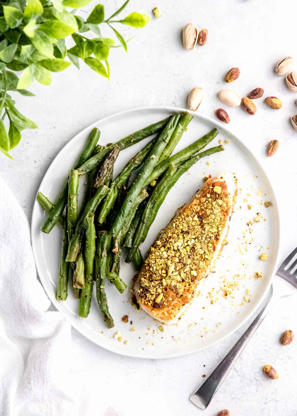 overhead image of pistachio crusted halibut on white plate