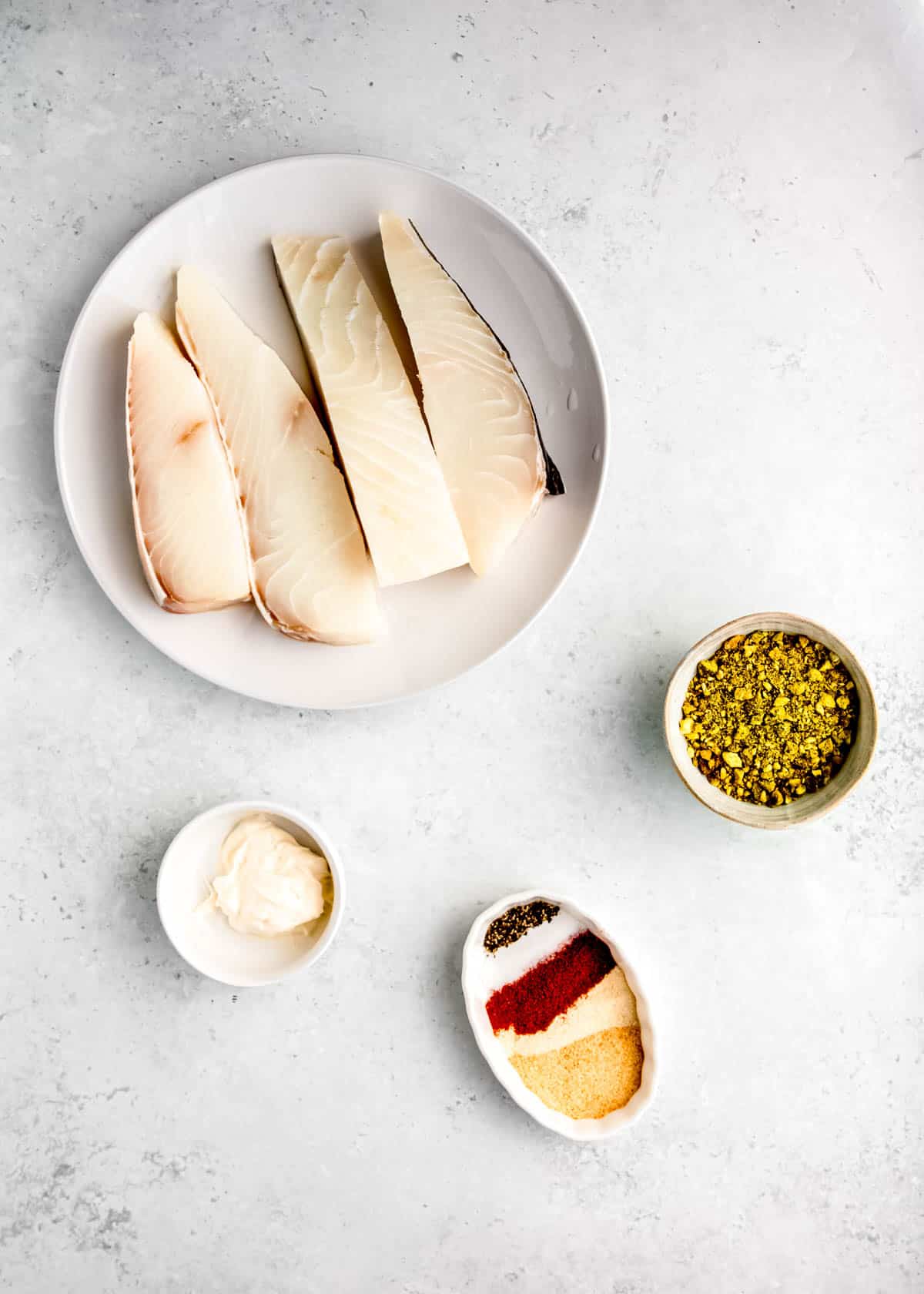 pistachio crusted halibut ingredients on a white table