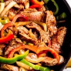 close up, overhead image of steak and peppers in black skillet