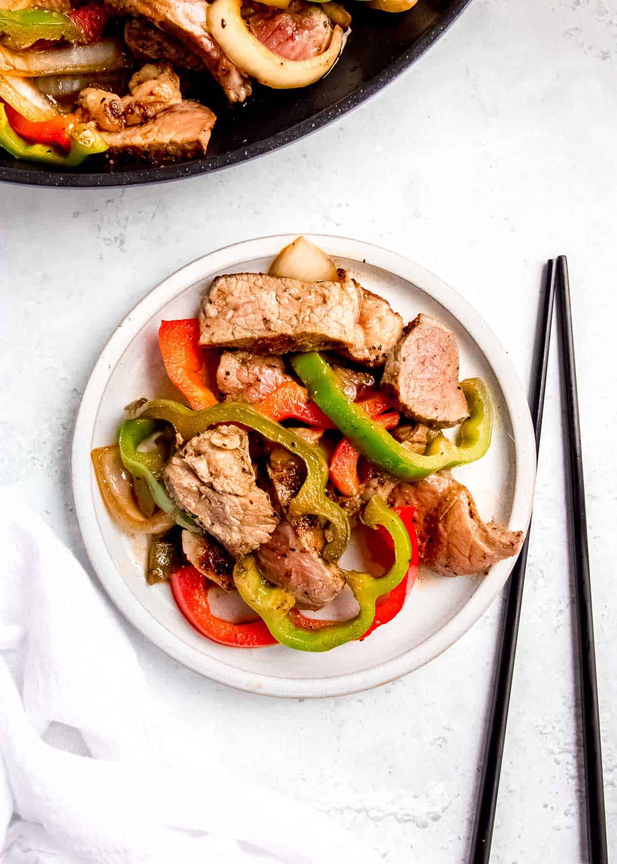 overhead image of steak and peppers on white plate