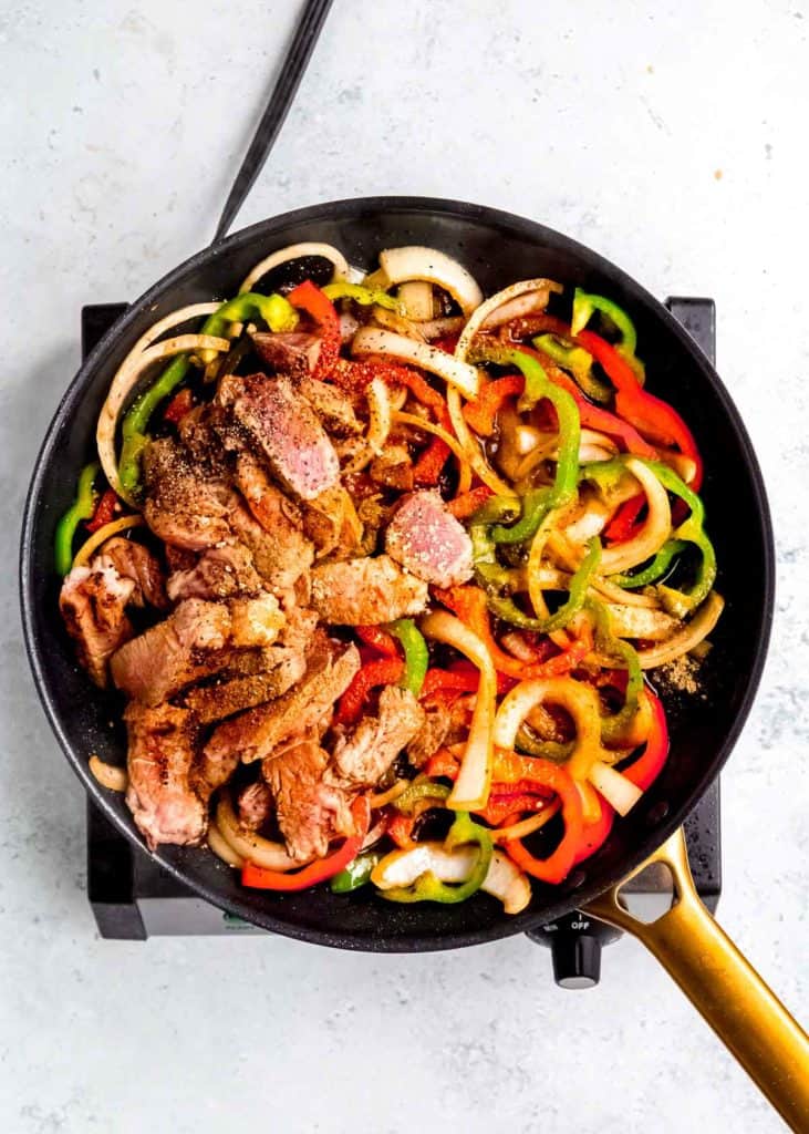 sauce being added to pepper steak skillet