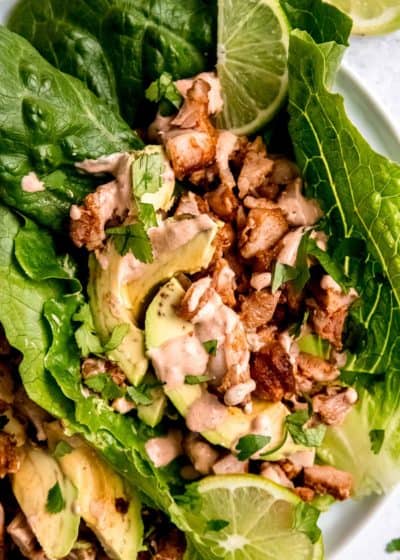broad lettuce leaves holding seasoned chipotle chicken, avocado slices, and a delicious sauce