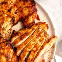 a platter of easy grilled chipotle chicken, some sliced, some whole