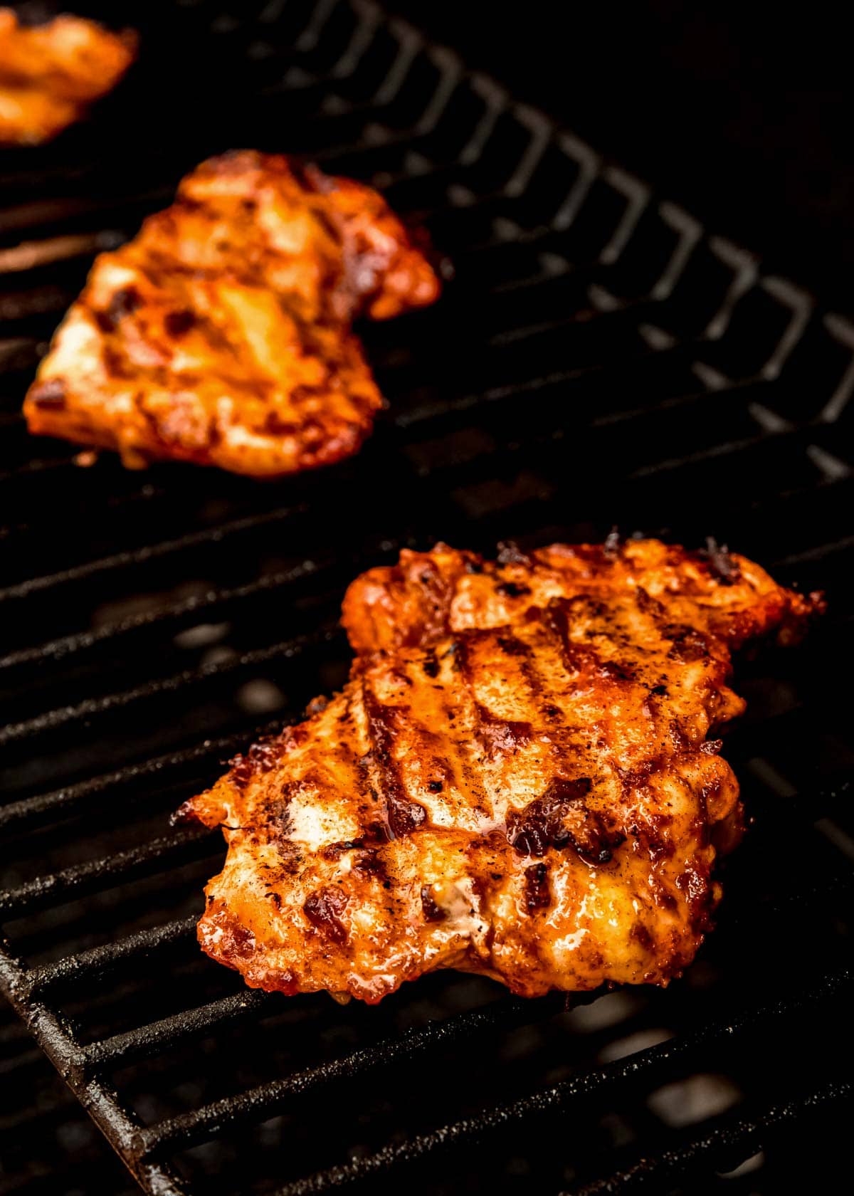 marinated chicken thighs cooking on a hot grill