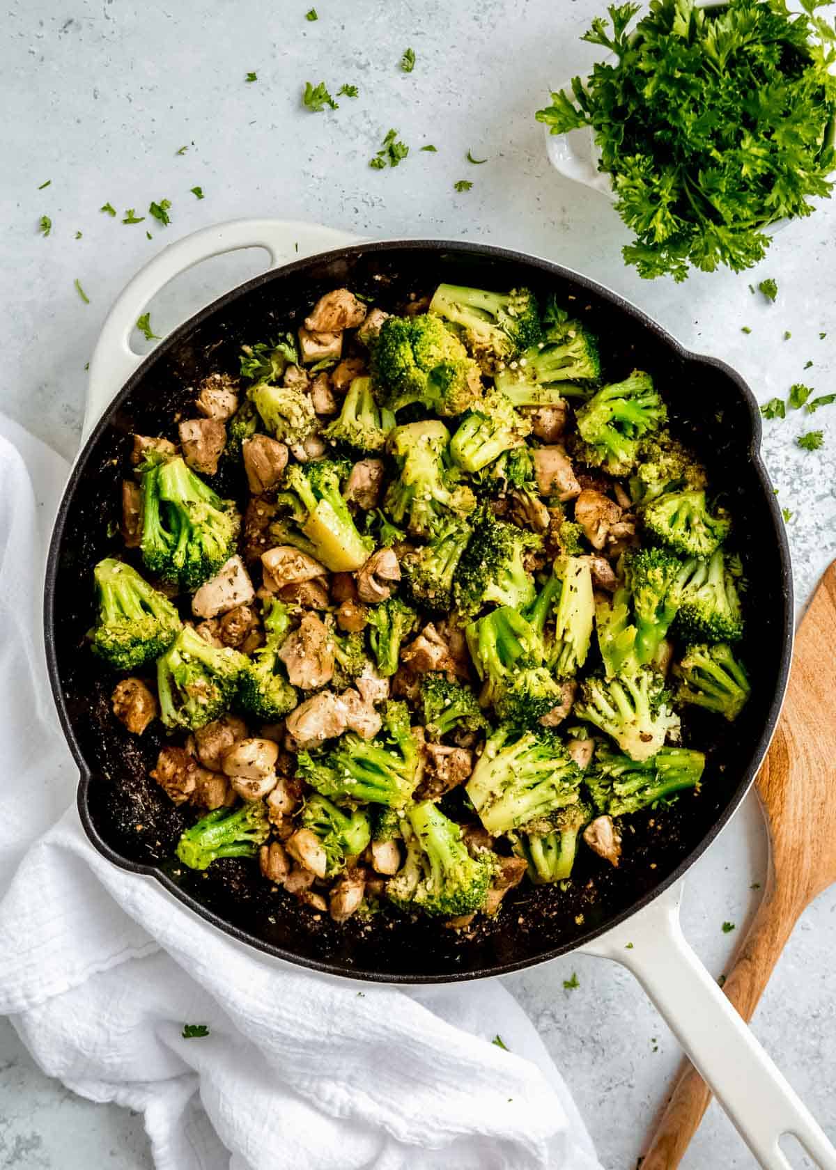 overhead shot of garlic butter chicken broccoli skillet garnished with fresh herbs