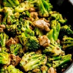 a large skillet filled with chicken and broccoli coated in garlic butter.